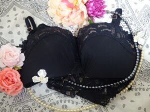 ブラックのブラジャーの周りにちりばめられたバラとジュエリー