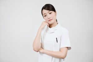 悩む白衣の女性