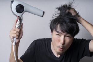 ドライヤーをかける男性